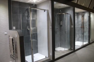  A row of three glass shower cubicles in a showroom.