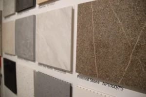 A range of ceramic tiles displayed on a wall within a showroom. The tiles names are displayed below each square tile.
